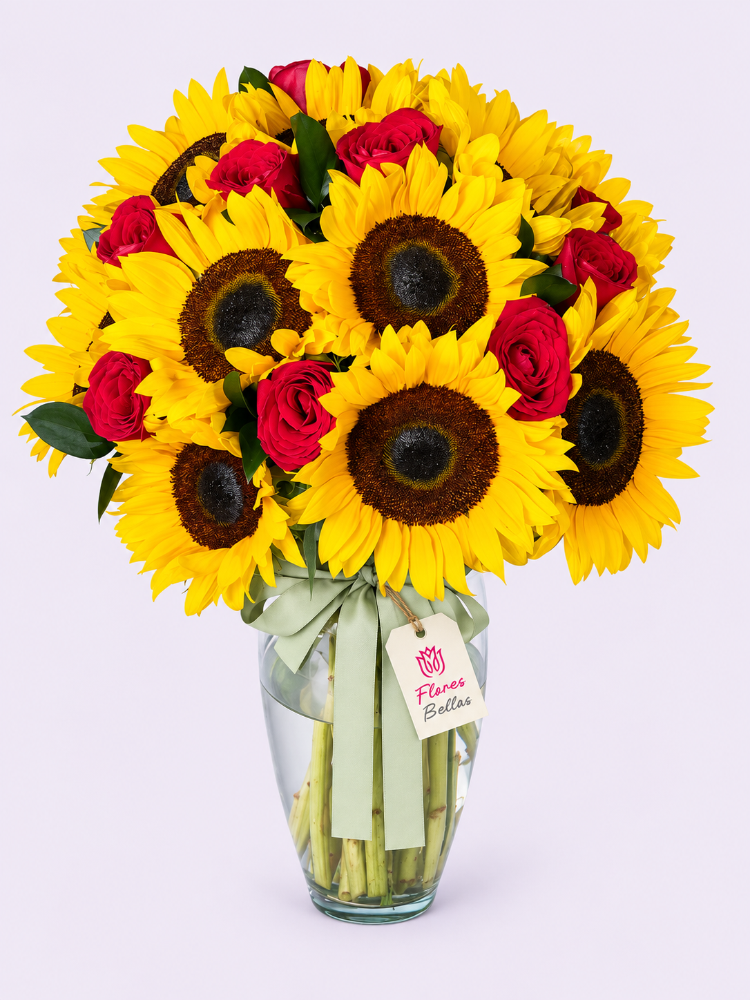 Arreglo de rosas rojas y girasoles amarillos en florero de vidrio con moño verde y etiqueta Flores Bellas.