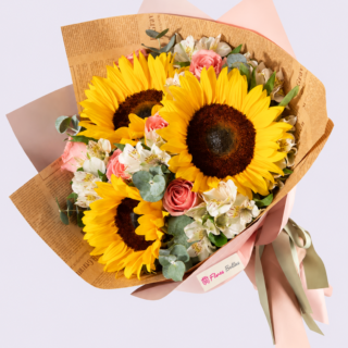 Ramo de girasoles amarillos, rosas rosadas y alstroemerias blancas con envoltura rosa