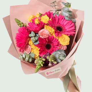 Ramo de gerberas fucsia y rosas amarillas y rosadas con eucalipto en envoltura rosa
